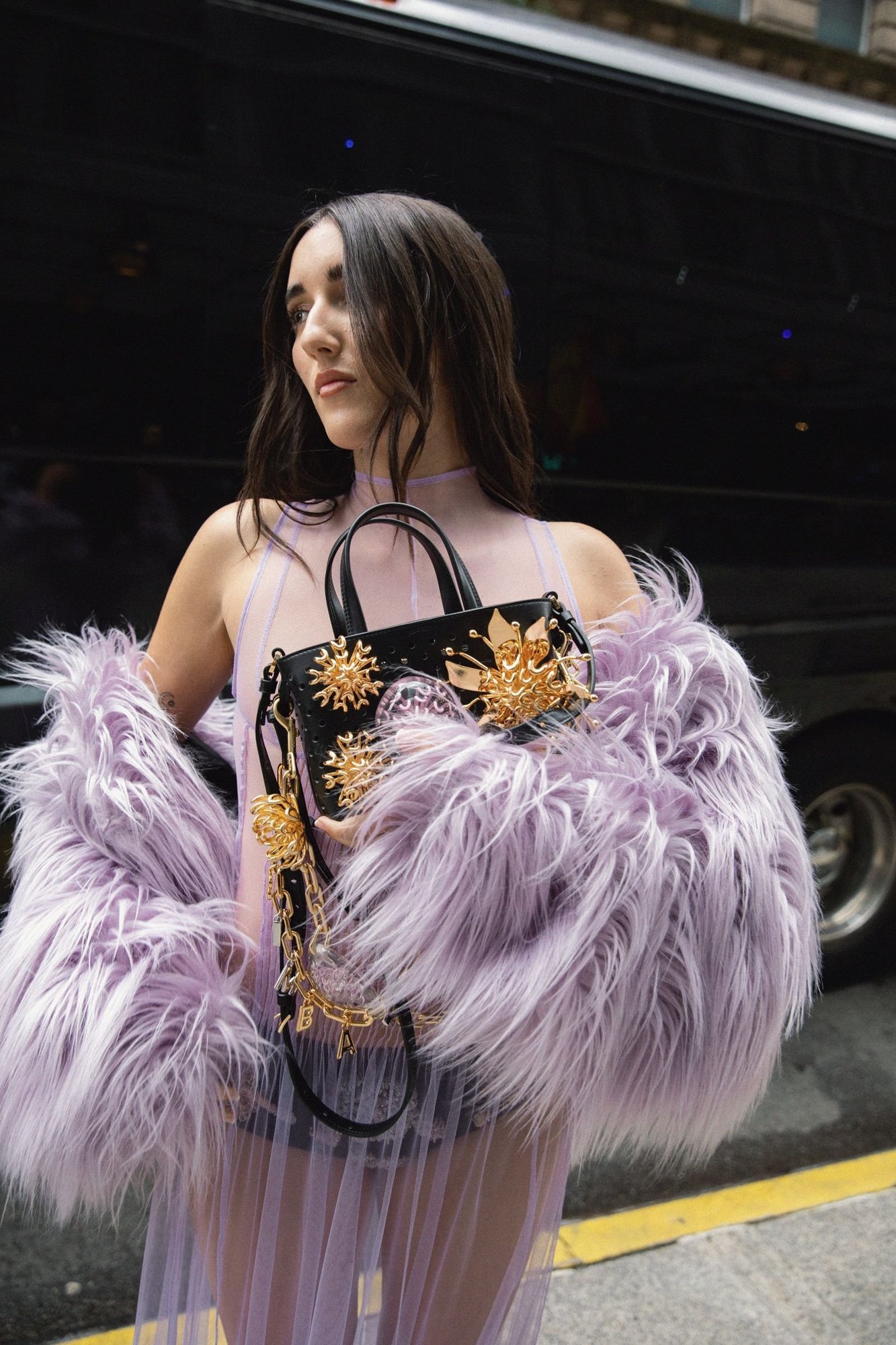 Judeline on a New York street holding an embellished Bimba y Lola bag, soft center-parted lengths