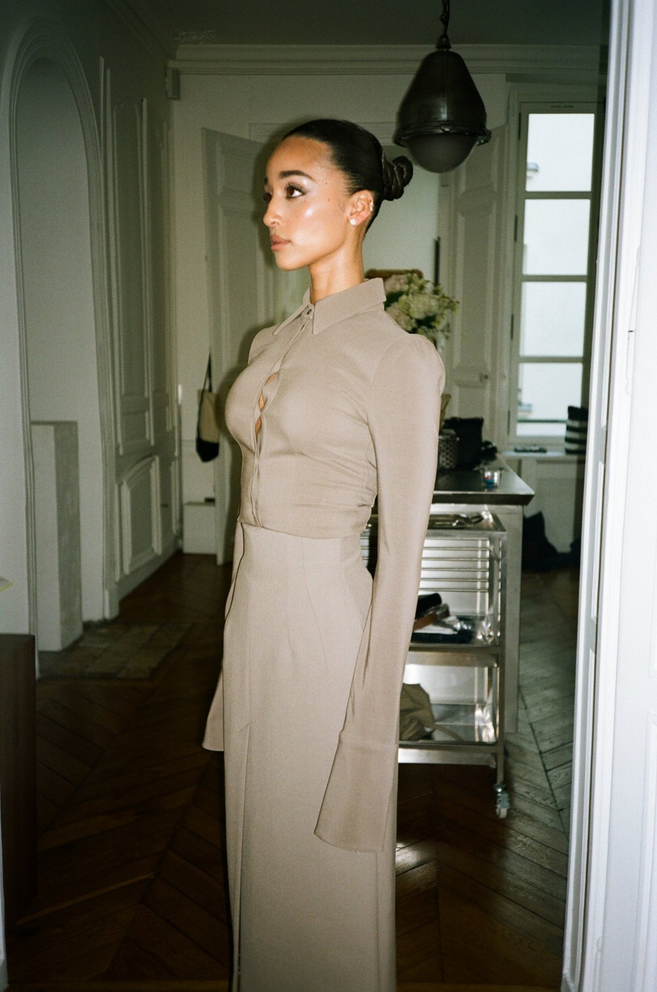 Eloise Dufka in profile in the apartment, sleek sculpted bun