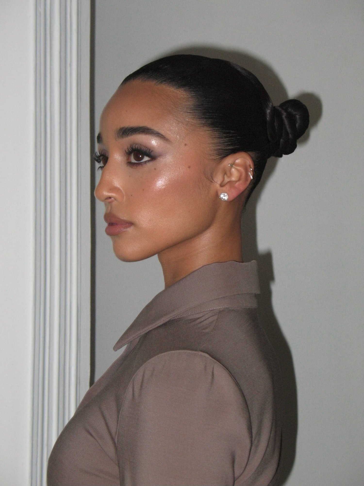 Behind the scenes: close profile of Eloise Dufka, slicked hairline and coiled bun