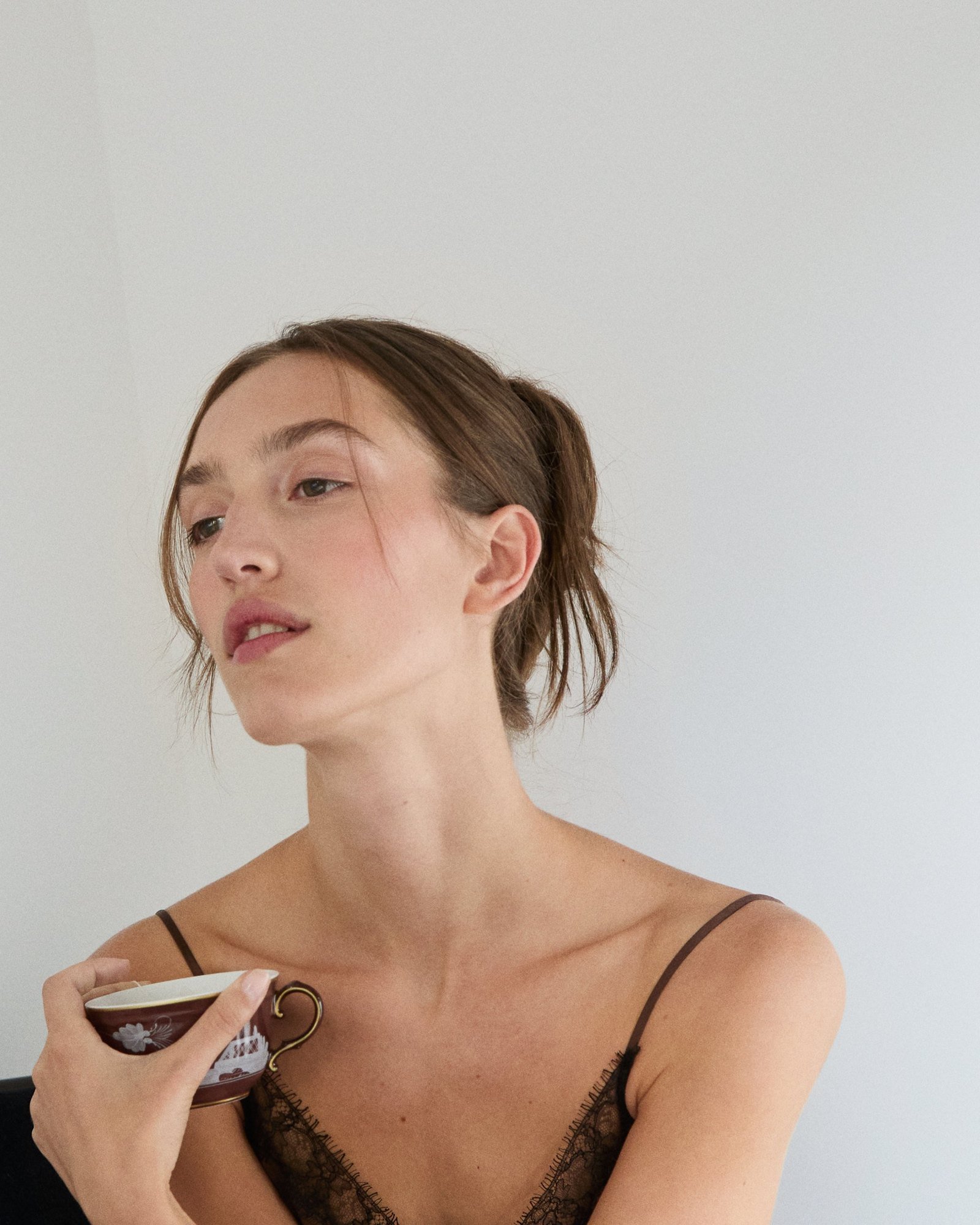 Soft undone knot with face-framing pieces, holding a teacup
