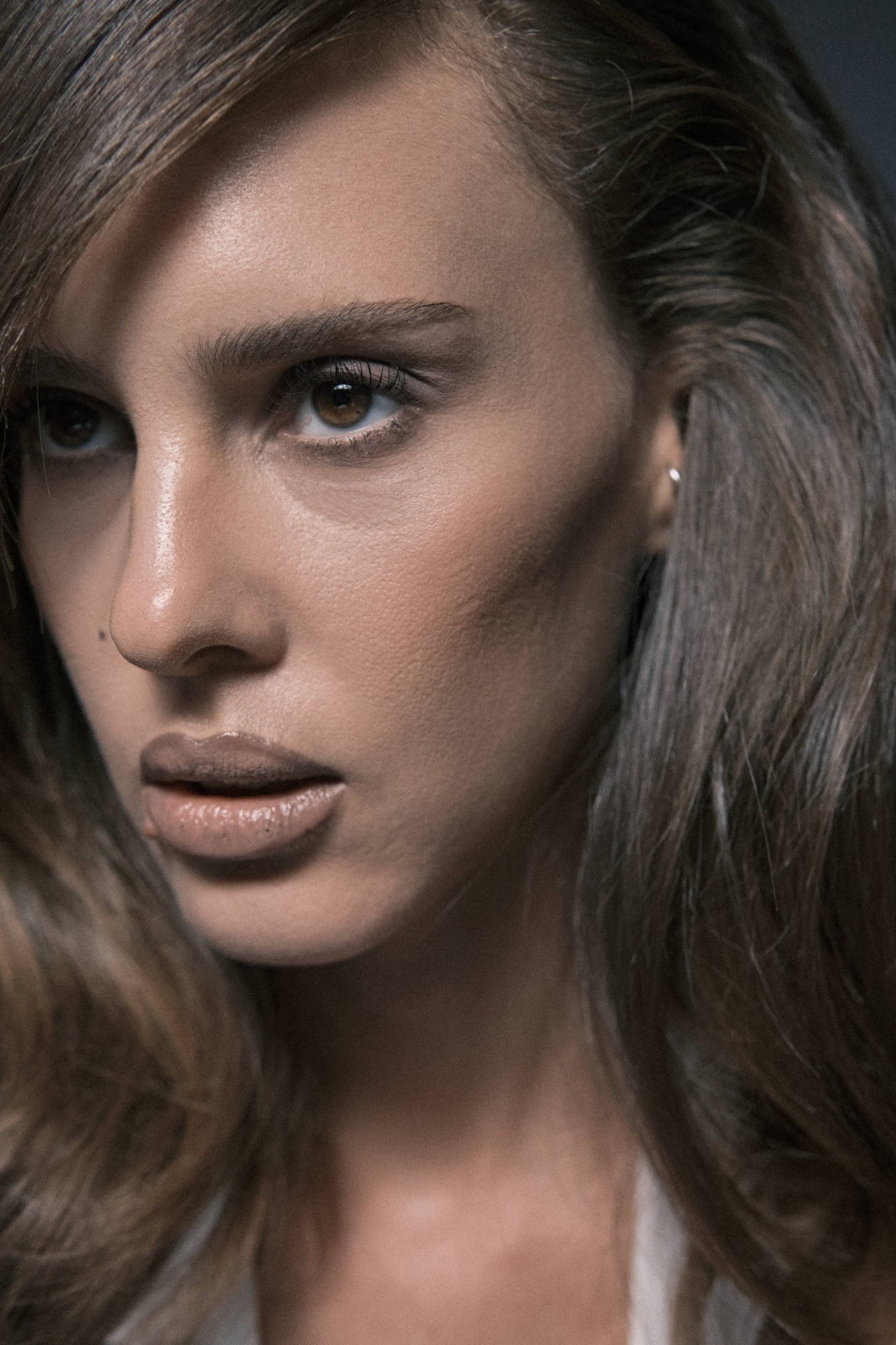 Extreme close-up of Tess, side-swept fringe and glowing skin